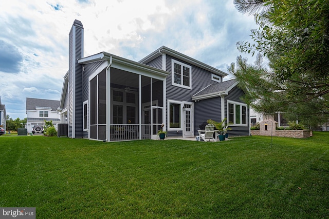 rear view of property featuring a lawn, a sunroom, a patio area, and central air condition unit