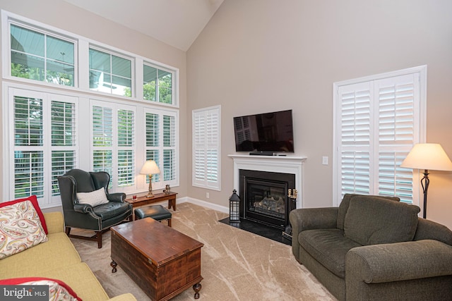 carpeted living room with high vaulted ceiling and plenty of natural light