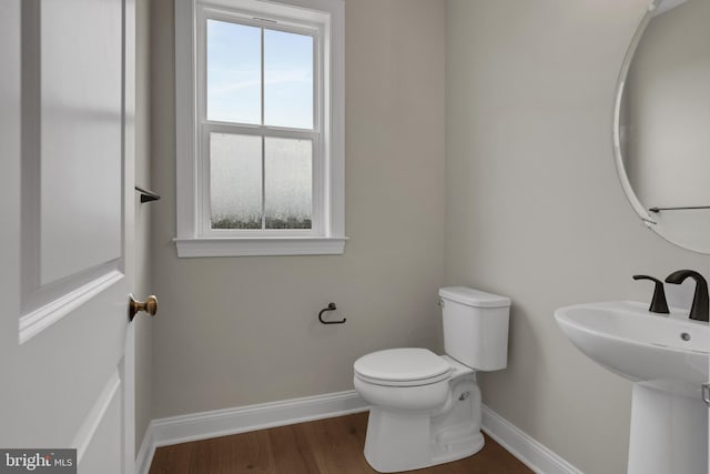 bathroom with hardwood / wood-style flooring and toilet