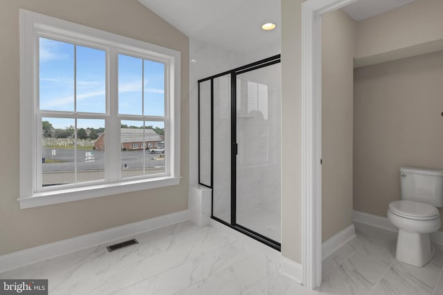 bathroom featuring vaulted ceiling, toilet, and a shower with shower door