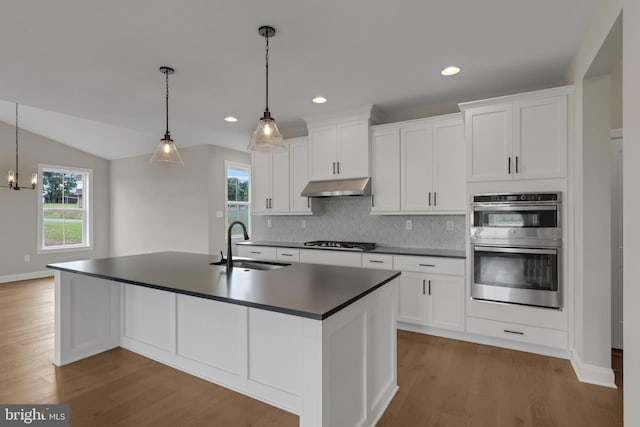 kitchen featuring white cabinetry, sink, stainless steel appliances, and decorative light fixtures