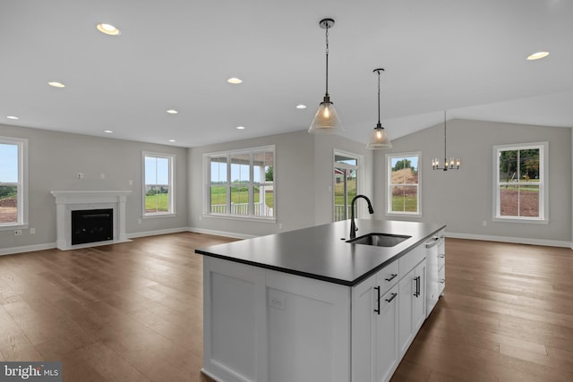 kitchen featuring white cabinetry, plenty of natural light, an island with sink, and pendant lighting