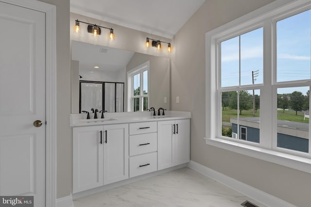 bathroom featuring plenty of natural light, a shower with shower door, and vaulted ceiling