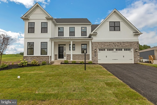 view of front of house with covered porch, a garage, and a front yard