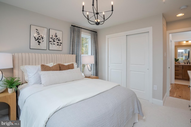 bedroom featuring multiple windows, light carpet, a chandelier, and a closet