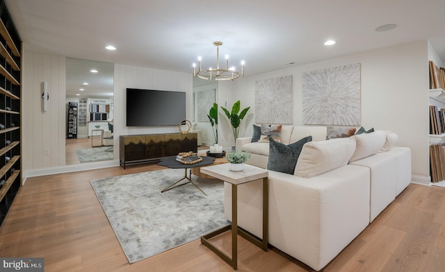 living room with light wood-type flooring and an inviting chandelier