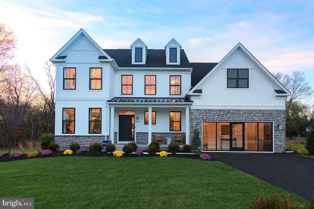 exterior space featuring covered porch and a yard