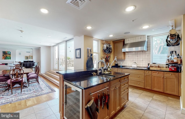 kitchen with sink, light tile floors, beverage cooler, tasteful backsplash, and wall chimney exhaust hood