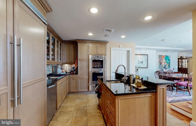 kitchen with light tile flooring, stainless steel appliances, a kitchen island with sink, and sink