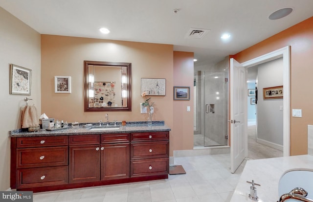 bathroom featuring a shower with door, tile flooring, and vanity with extensive cabinet space