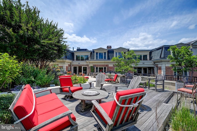 wooden deck with an outdoor living space with a fire pit