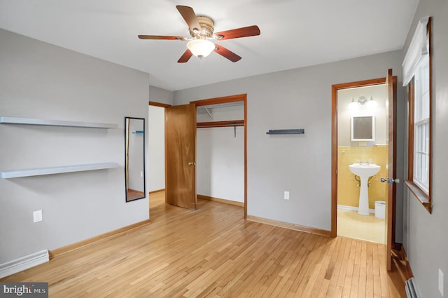 unfurnished bedroom with ceiling fan, light hardwood / wood-style flooring, ensuite bath, and a closet