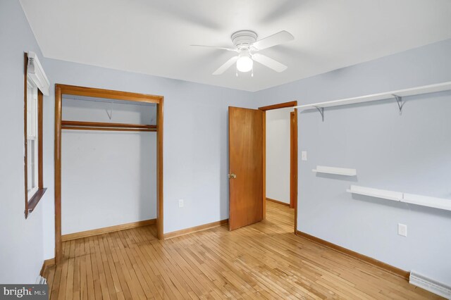 unfurnished bedroom with ceiling fan, a closet, and light wood-type flooring