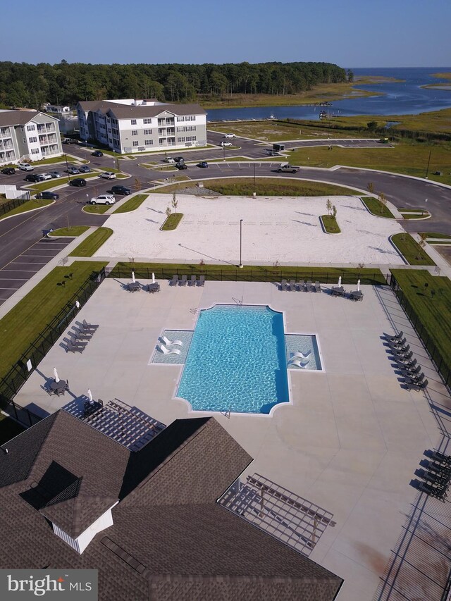 view of swimming pool featuring a patio and a water view