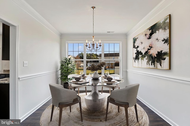 dining room featuring an inviting chandelier, ornamental molding, and dark hardwood / wood-style floors