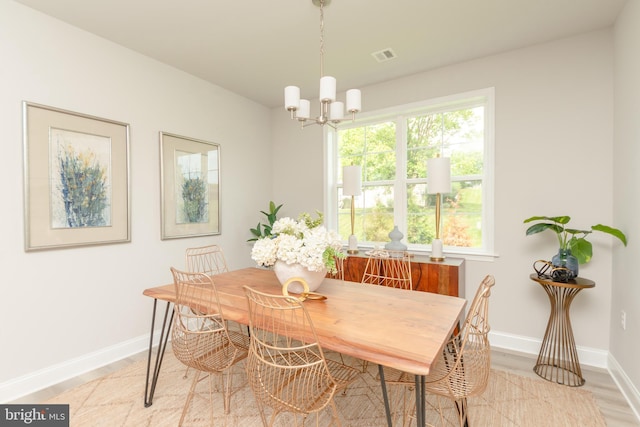 dining room with a notable chandelier and light wood-type flooring