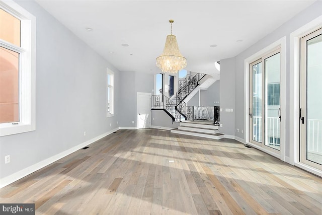 unfurnished living room featuring a chandelier and hardwood / wood-style flooring