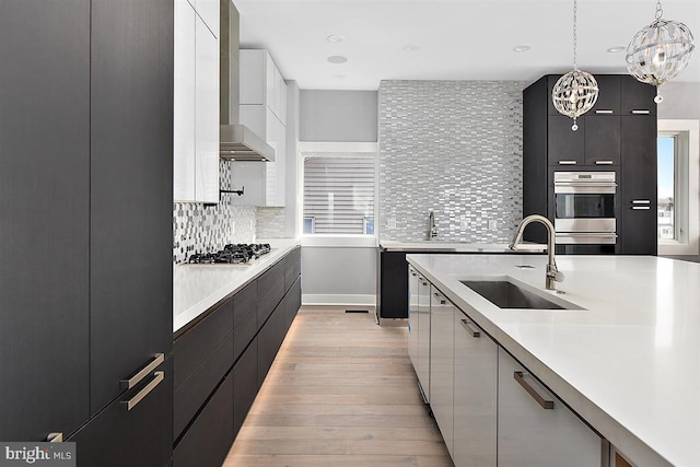 kitchen with sink, decorative backsplash, appliances with stainless steel finishes, decorative light fixtures, and white cabinetry