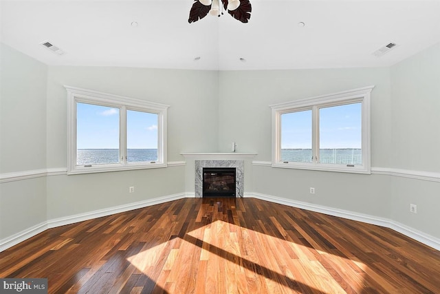 unfurnished living room with a wealth of natural light, a water view, and vaulted ceiling