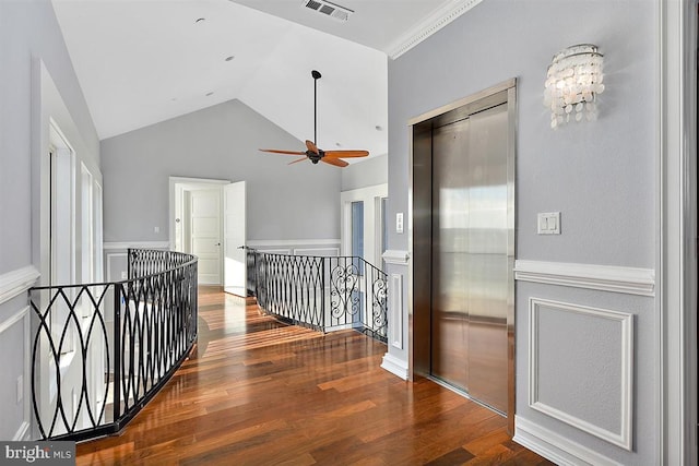 corridor with an inviting chandelier, elevator, vaulted ceiling, hardwood / wood-style flooring, and ornamental molding