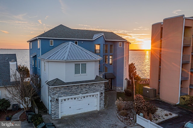 view of front of property featuring a garage and a water view