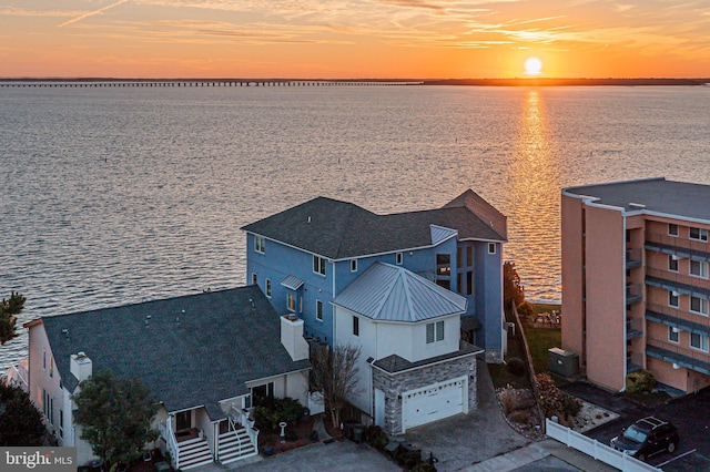 aerial view at dusk featuring a water view