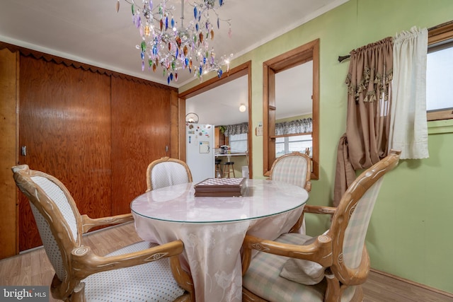 dining room featuring light hardwood / wood-style flooring, ornamental molding, and a chandelier