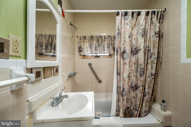 bathroom with shower / bath combination with curtain, tile walls, and vanity with extensive cabinet space