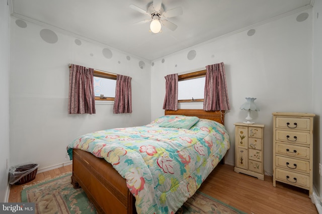 bedroom featuring ceiling fan, crown molding, and hardwood / wood-style flooring