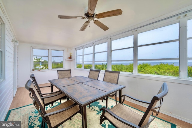 sunroom / solarium featuring ceiling fan, a water view, and a wealth of natural light