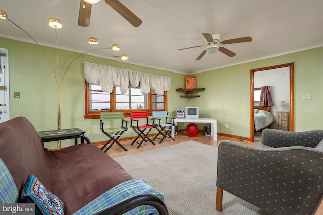 living room featuring ceiling fan, light wood-type flooring, and crown molding