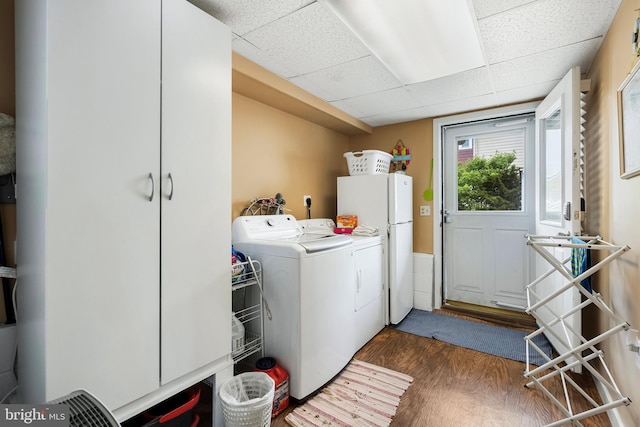 laundry room featuring dark hardwood / wood-style flooring, washing machine and clothes dryer, and hookup for an electric dryer