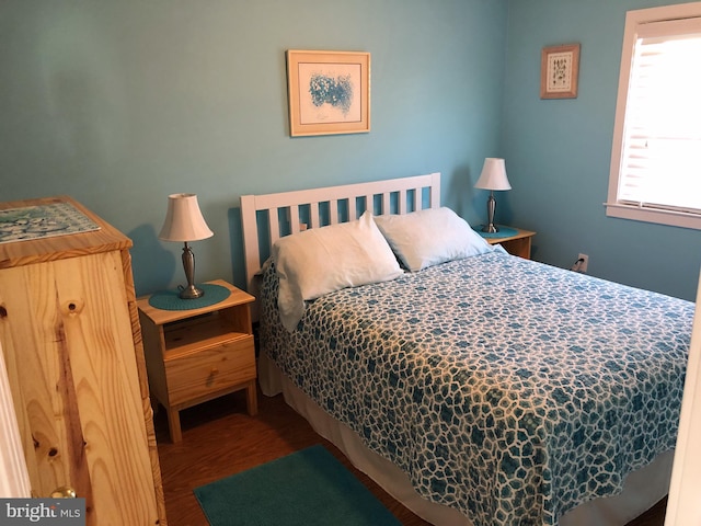 bedroom with dark hardwood / wood-style floors