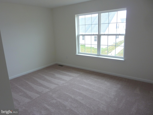 unfurnished room featuring light carpet