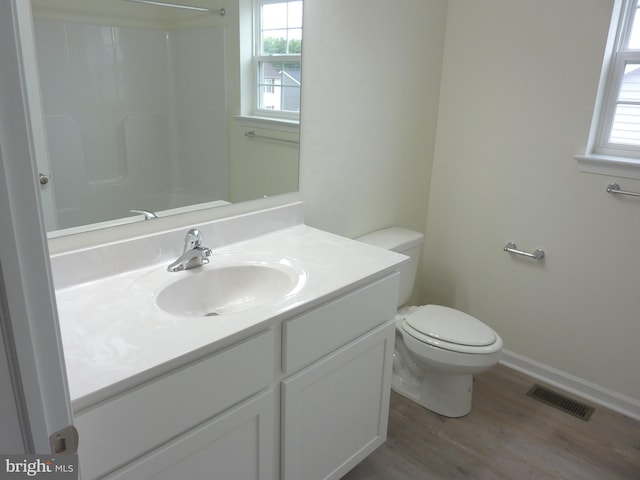 bathroom with plenty of natural light, hardwood / wood-style floors, toilet, and vanity