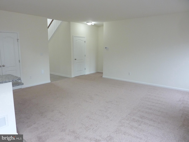 unfurnished room featuring light colored carpet