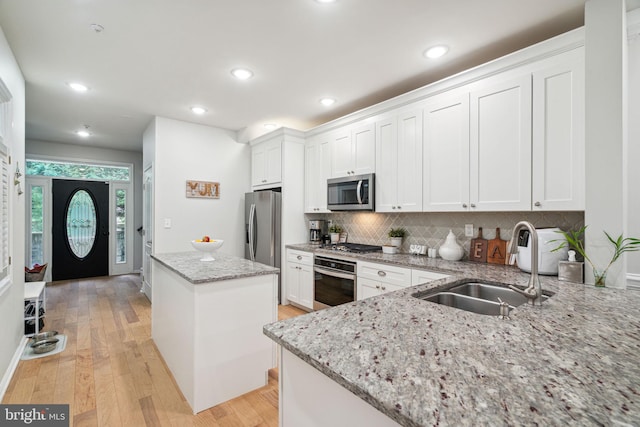 kitchen with white cabinets, a center island, and appliances with stainless steel finishes