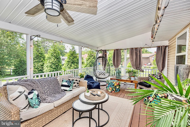 sunroom with ceiling fan, a wealth of natural light, and vaulted ceiling