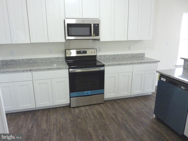 kitchen featuring dark hardwood / wood-style floors, light stone countertops, appliances with stainless steel finishes, and white cabinetry