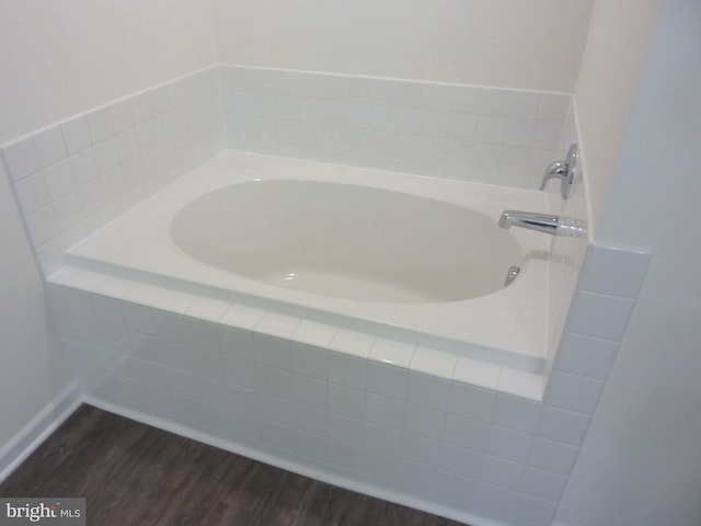 bathroom with hardwood / wood-style floors and tiled tub