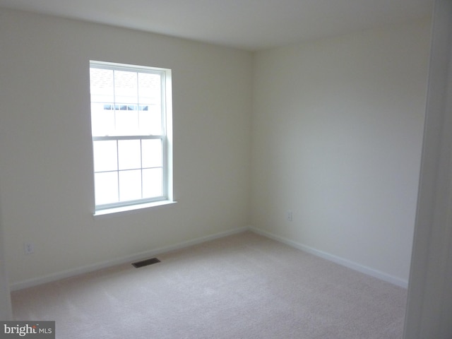 unfurnished room with light carpet and plenty of natural light