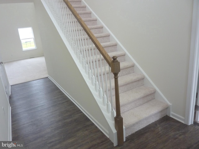 stairway with dark hardwood / wood-style flooring