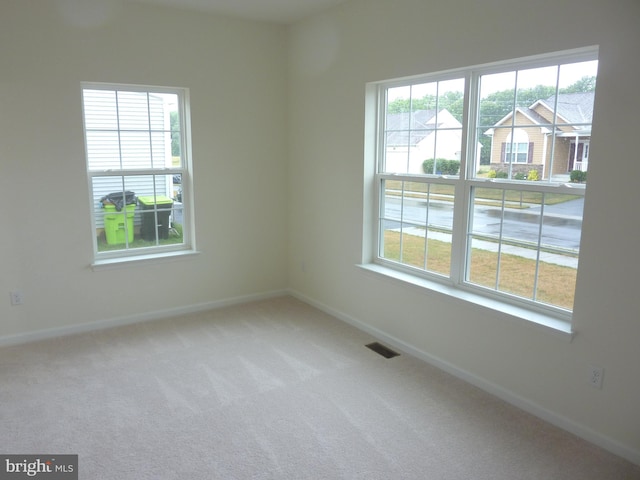 carpeted empty room with plenty of natural light