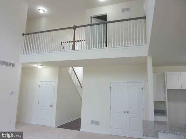 stairway with a high ceiling and wood-type flooring