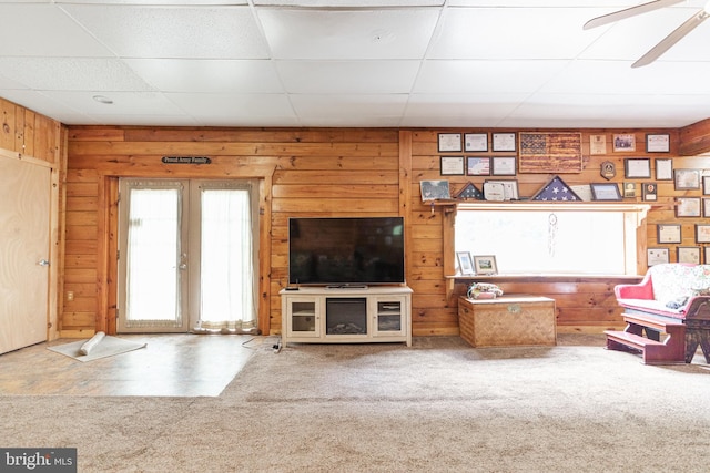 unfurnished living room with a paneled ceiling, french doors, carpet flooring, and ceiling fan