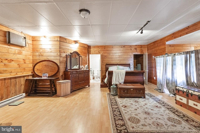 sitting room featuring a baseboard radiator, a paneled ceiling, light hardwood / wood-style floors, and wooden walls