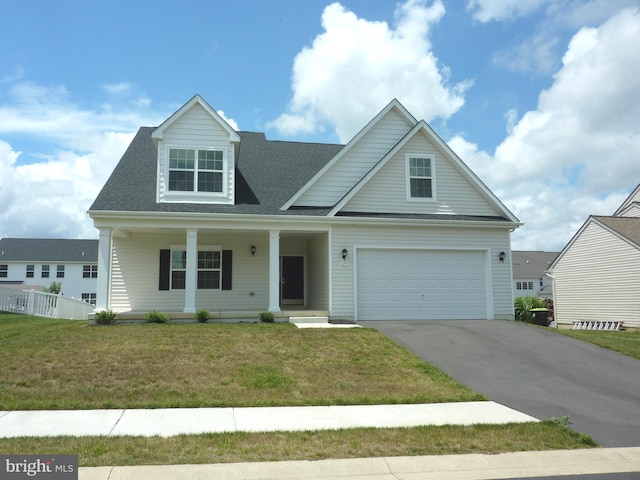 view of front facade featuring covered porch, a front lawn, and a garage