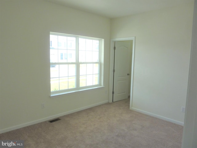 unfurnished room featuring plenty of natural light and light colored carpet