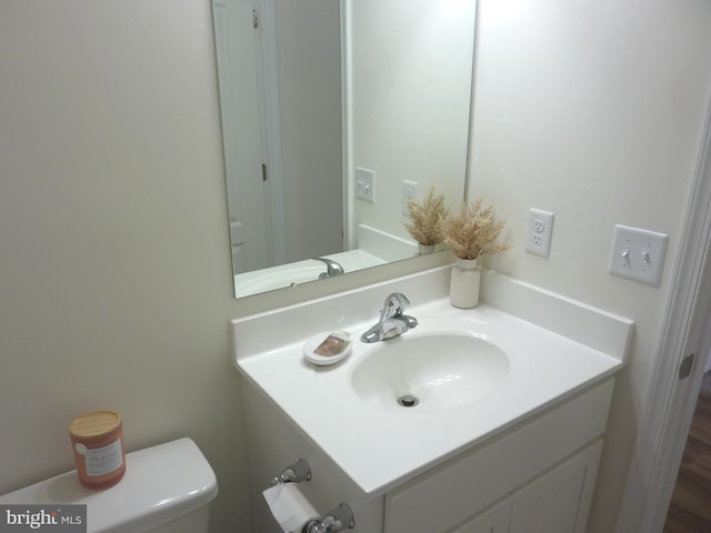 bathroom featuring hardwood / wood-style flooring, toilet, and vanity