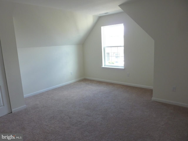 bonus room featuring light carpet and vaulted ceiling